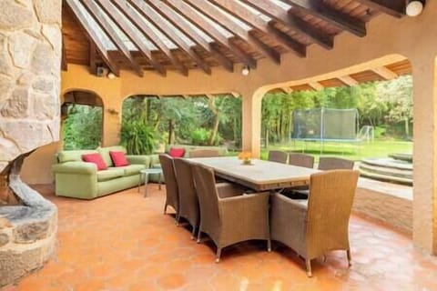 Agradable terraza exterior con mesa de comedor y chimenea