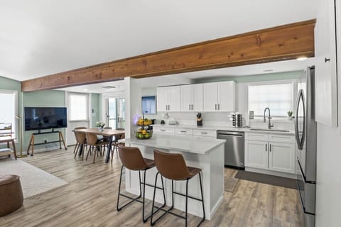 Modern kitchen with island seating and adjacent dining area. Perfect for cooking and enjoying meals together. ️‍