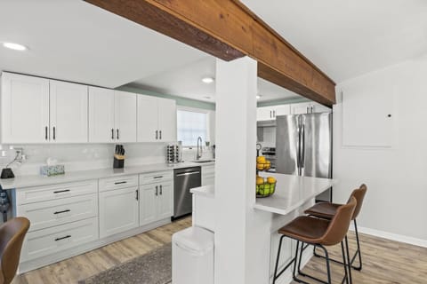 Spacious kitchen with sleek white cabinets and a breakfast bar, ideal for family gatherings in Clairmont, Honeoye. ️✨