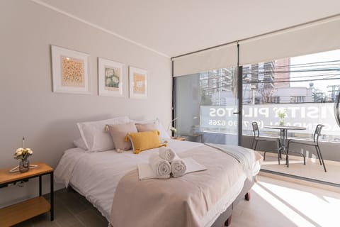 Relax in this bright bedroom with a cozy bed and private balcony, perfect for enjoying city views and morning coffee.