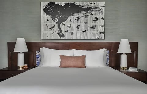 Sink into crisp linens beneath bold artwork and warm lighting.