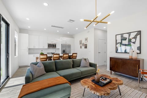 Relax on our green plush sofa, perfectly positioned with the kitchen just behind, blending comfort and convenience