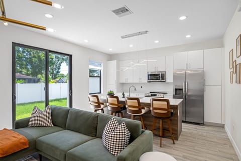 Relax on our green plush sofa, perfectly positioned with the kitchen just behind, blending comfort and convenience