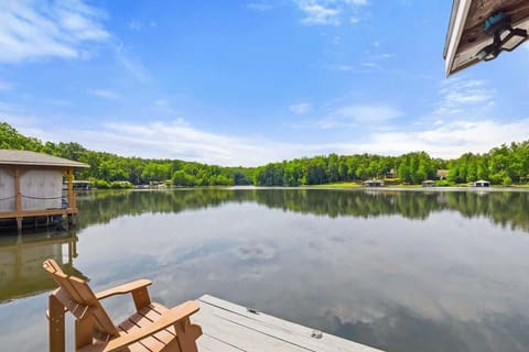 A serene lakeside view from a dock equipped with Adirondack chairs, perfect for enjoying peaceful moments by the water.