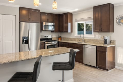 A fully equipped kitchen with granite counters and bar seating for quick breakfasts.