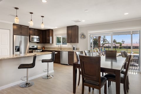 The dining table sits right between the kitchen and living room with golf course views.
