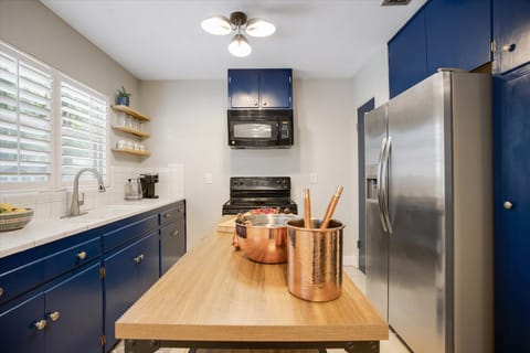 "Gourmet Kitchen with Bold Modern Style"
Cook in style with our striking navy cabinetry, sleek stainless steel appliances, and a spacious wooden island perfect for meal prep.