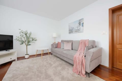 Modern bedroom with a sofa bed, TV and access to balcony.