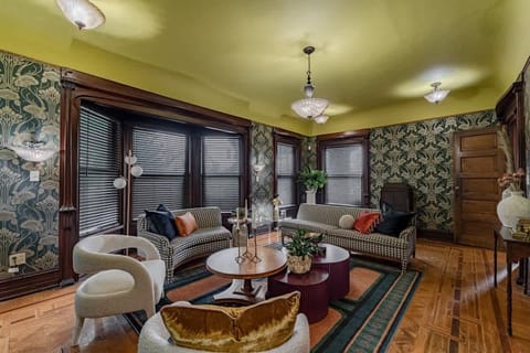 Large, cozy living room w/ patterned walls, comfy seating & warm lighting for relaxed evenings together