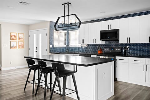 A large island and three black barstools at the center