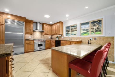 Gourmet kitchen with ample prep space, filtered water, and wine glasses.