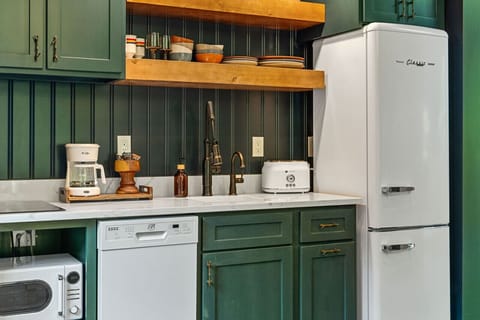 The kitchen features a two-burner electric cooktop, ice maker, microwave, toaster, blender, dishwasher, and refrigerator, along with a coffee maker that uses our custom Hideout coffee blend.