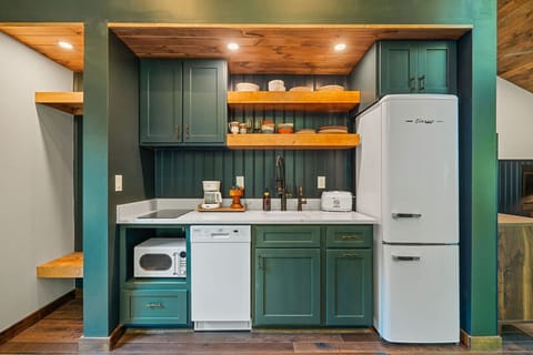 The kitchen features a two-burner electric cooktop, ice maker, microwave, toaster, blender, dishwasher, and refrigerator, along with a coffee maker that uses our custom Hideout coffee blend.