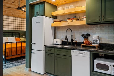 The kitchen features a two-burner electric cooktop, ice maker, microwave, toaster, blender, dishwasher, and refrigerator, along with a coffee maker that uses our custom Hideout coffee blend.