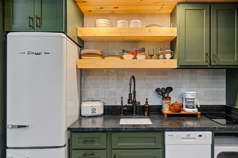 The kitchen features a two-burner electric cooktop, ice maker, microwave, toaster, blender, dishwasher, and refrigerator, along with a coffee maker that uses our custom Hideout coffee blend.