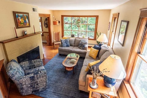 Cozy living room with plenty of seating, bay window and piano.