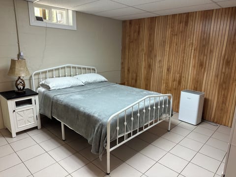 Queen bed with wardrobe and nightstand.