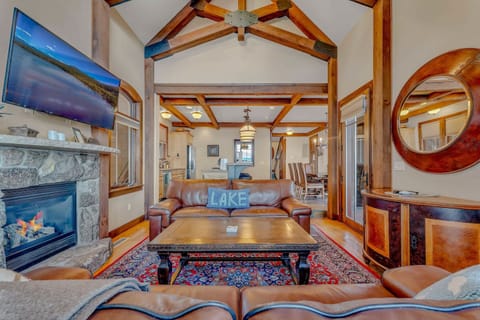 Living Room: 2 leather couches, 50” Smart TV, gas fireplace w/stone mantle, open layout to the kitchen, windows overlooking the lake,  soaring windows w/lake views
