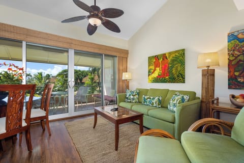 Unwind in your breezy tropical living room, where vibrant green furnishings and lush palm artwork create a relaxing island vibe. Step through sliding doors to your private balcony overlooking palm trees and sunshine.