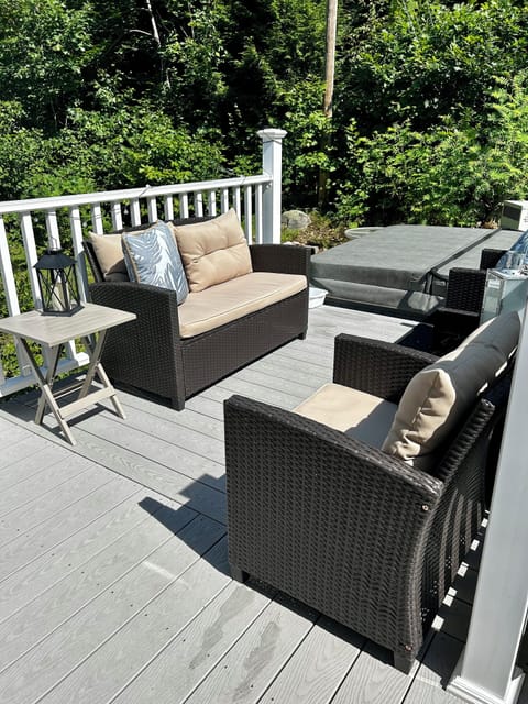 Completely private back deck with seating area next to hot tub.
