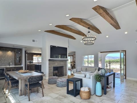 This stunning great room features a spacious and comfortable sectional sofa, perfect for lounging and socializing. The modern dining table, situated nearby, offers ample seating for family meals or gatherings.