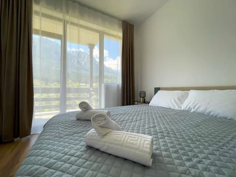 The first bedroom featuring a queen-size bed equipped with freshly cleaned linens, fluffy pillows, soft towels, bedside table, room-darkening shades, standard TV and a wonderful mountain view