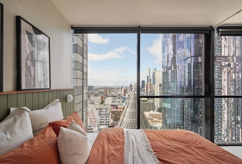 The second bedroom enjoys city views from the queen-size bed framed by floor-to-ceiling windows. 