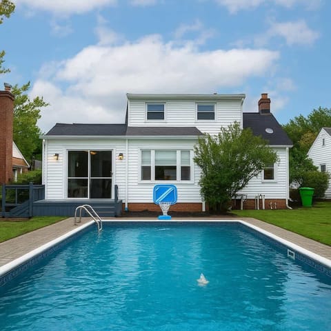 Spacious backyard pool w/ lounge chairs & a clean patio, perfect for sunny afternoons