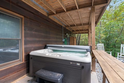 A covered deck area with a large hot tub, perfect for relaxation,.