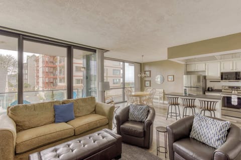 Modern open-concept living space with large windows, cozy seating, spacious dining area, and a bright, inviting atmosphere for comfortable family living.