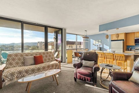 Open-concept living and dining area with large windows, comfortable seating, and plenty of natural light.