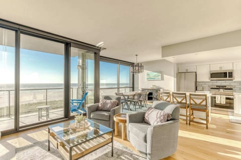 A modern, open-concept living space with large windows, cozy seating, a spacious dining area, and a bright, inviting atmosphere.  