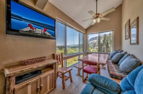 Relax in a cozy living area featuring a comfy couch, a TV, and stunning windows that invite natural light.