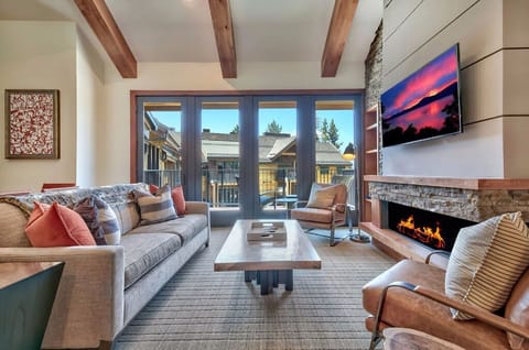 Relax in this inviting living space, complete with a fireplace, comfortable seating, and stunning views through large windows.
