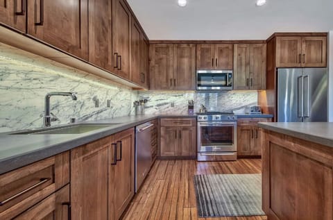 Prepare meals with ease in this fully equipped kitchen, boasting stainless steel appliances, granite countertops, and custom cabinetry.