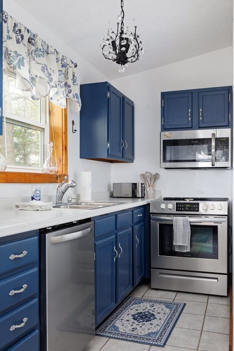 Charming kitchen w/ blue cabinets, white countertops & plenty of space to cook & gather.