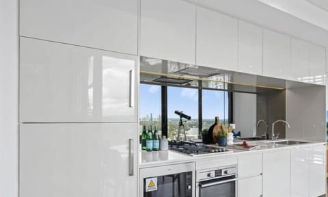A sleek, modern kitchen with white cabinetry and large windows providing abundant natural light.