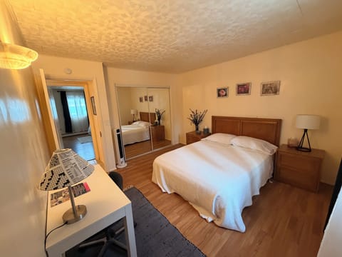 Bedroom #2 is equipped with a queen-size bed and a workspace table and chair. 
