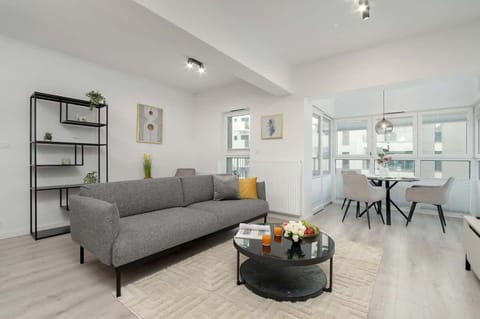 A modern, airy living space with soft grey furnishings and tasteful decor, perfect for relaxing or entertaining guests.