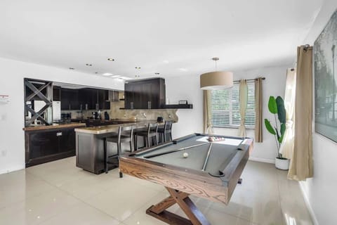 Entertainment-ready space with pool table—perfect for vacation rentals and short-term stays. Enjoy sleek kitchen, game zone, and natural light ideal for relaxing, hosting, or remote work.