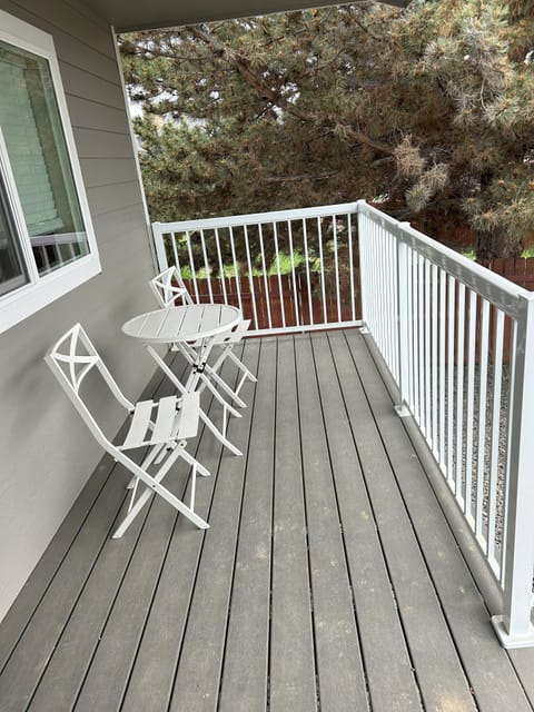 Backyard patio deck with two chairs and a table.