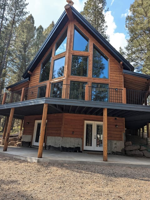 Front of cabin, large windows and beautiful mature trees. 