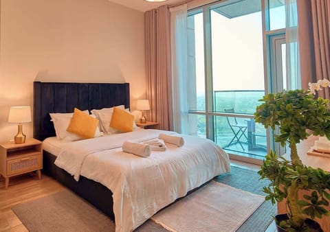 Modern Suite with Skyline Views – Enjoy a stylish bedroom with soft lighting, elegant furnishings, and a stunning cityscape.