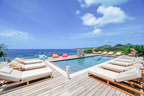 Heated pool surrounded by a spacious sun terrace with deckchairs. Panoramic views over Anse des Cayes. 