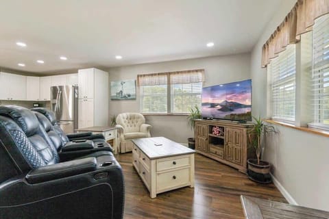 Relax in style with a reclining couch with built-in chargers, a big-screen smart TV, and a cozy easy chair in our open-concept living space. Great furnishings, new flooring, and fresh decor, creating a comfortable atmosphere for you to enjoy.