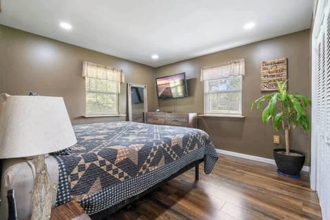 The main bedroom features a spacious and comfortable king-size adjustable bed, lamps, a big-screen Smart TV, ample storage, and a roomy closet, providing everything you need for a restful and organized stay.
