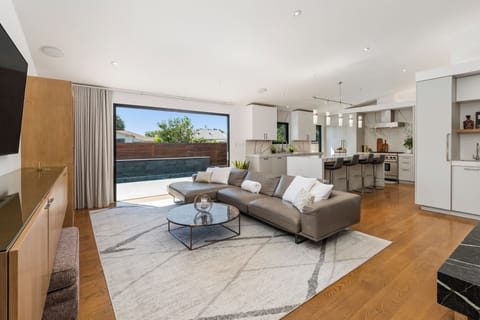 Open concept living room and kitchen with sleek cabinetry and a central island.