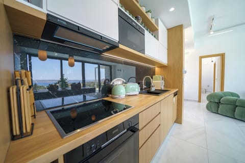 Left Building: The kitchen is fully equipped with modern appliances, making self-catering a breeze, and features an island with four stools