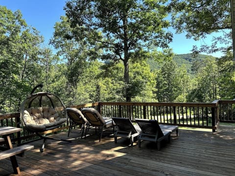 The deck features lounge chairs, a picnic table, a swinging chair, and 2 grills