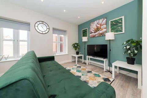 Bright and stylish living room area featuring modern decor a comfy area sofa, smart tv, and natural light perfect for relaxing after a day of exploring or working